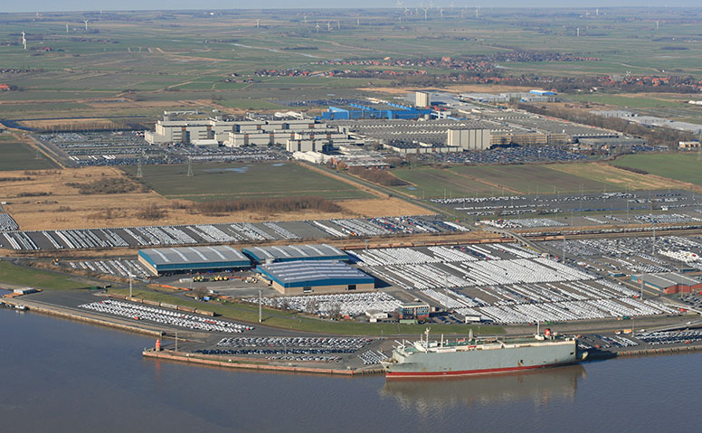 Automobile handling: Aerial view of the Emden outer harbor with a view of the entire operating area of Anker Schiffahrt. At the pier, there is a car carrier