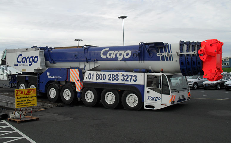 Port Specific Services: A blue and white Cargo crane with telescopic boom on a parking lot